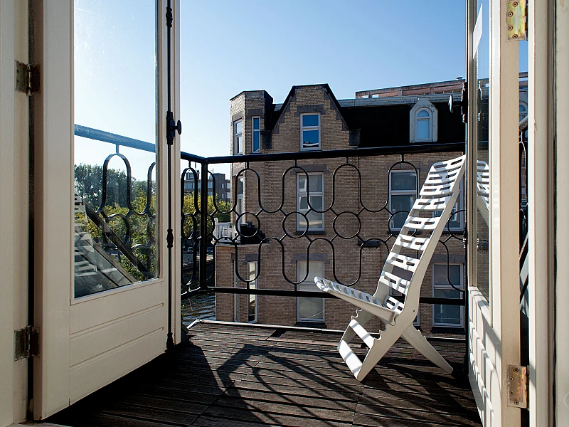 Bedroom with the view of balcony Canal Holiday apartment Amsterdam